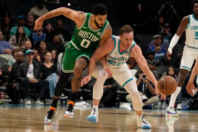 Oct 19, 2023; Charlotte, North Carolina, USA; Charlotte Hornets forward Gordon Hayward (20) tries to keep possession pressured by Boston Celtics forward Jayson Tatum (0)during the first quarter at Spectrum Center. Mandatory Credit: Jim Dedmon-USA TODAY Sports