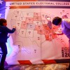 People color in a U.S. electoral map during a 2020 presidential election watch party at the U.S. Embassy in Ulaanbaatar, Mongolia.