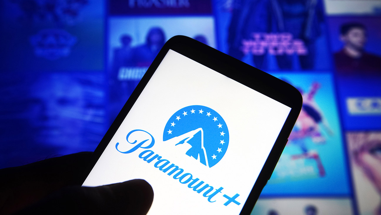 Paramount Plus logo is seen on a smartphone against its website in the background.