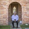 Robert Taylor sits outside the two-story home he built in Reserve, Louisiana. He built his two-story brick house around the same time the DuPont Plant started operating – now called Denka Performance Elastomer – is located walking distance from Taylor’s house in St. John Parish.