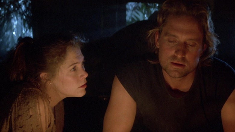 Joan (Kathleen Turner) listens to Jack (Michael Douglas) in Romancing The Stone