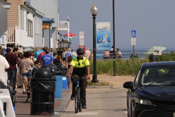 A Community Service Officer from the Old Orchard Beach Police Dept. patrols on a bicycle, Tuesday, July 29, 2025, in Old Orchard Beach, Maine. (AP Photo/Robert F. Bukaty)