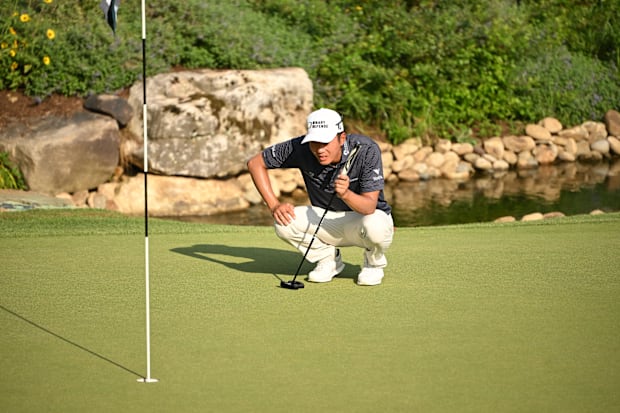 Michael Kim lines top a putt on the 18th hole 