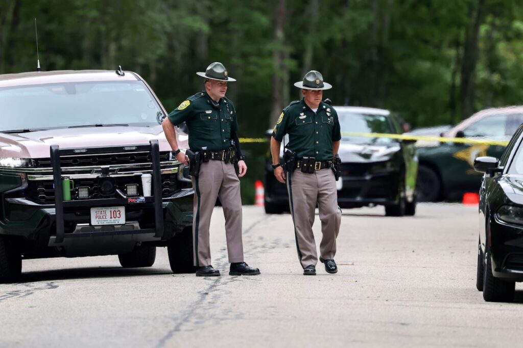 Authorities stand near a crime scene on Moharimet Drive in Madbury, N.H. on August 19, 2025, after two adults and two children were found dead inside a house.