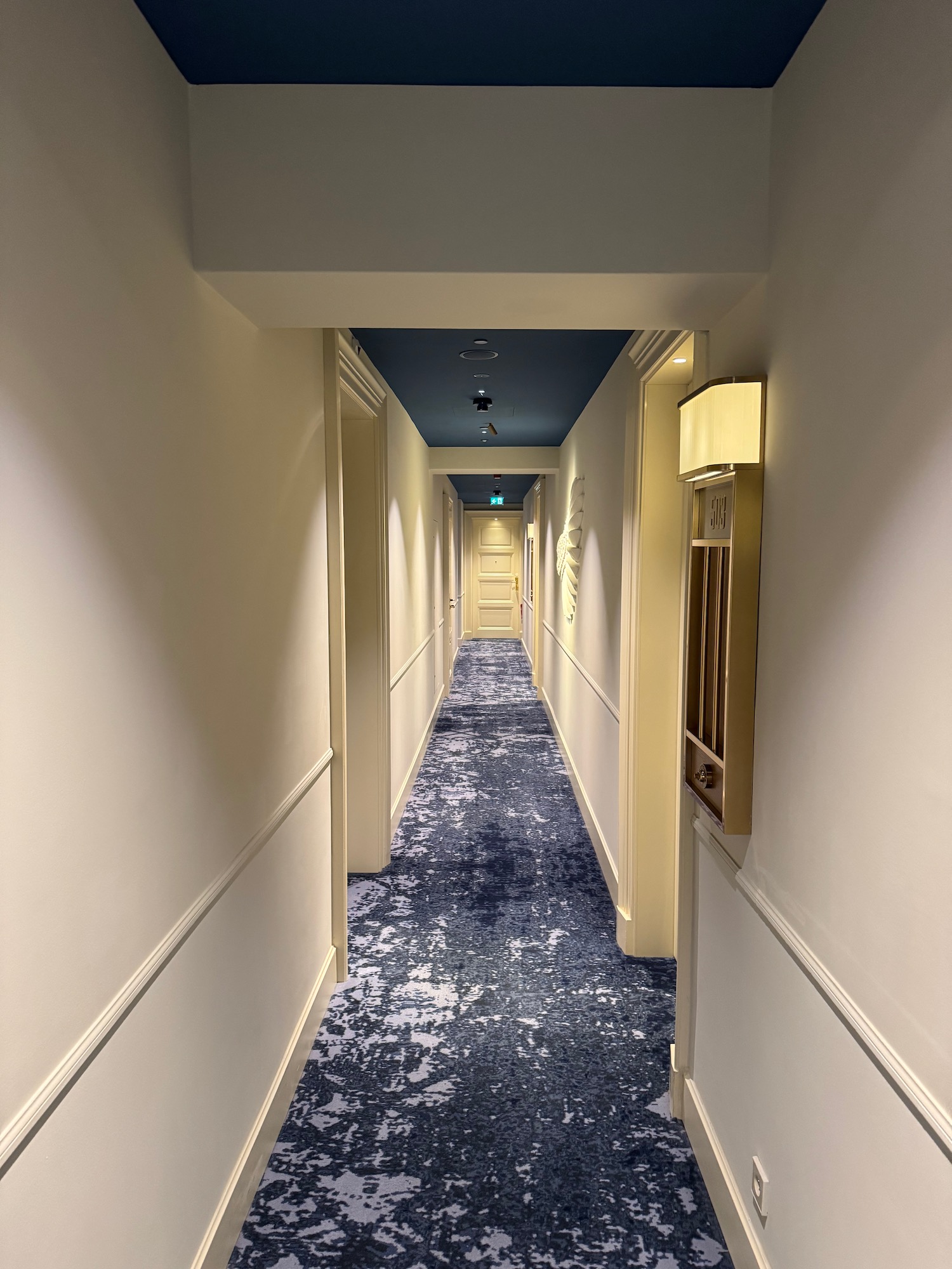 a hallway with blue carpet and white walls