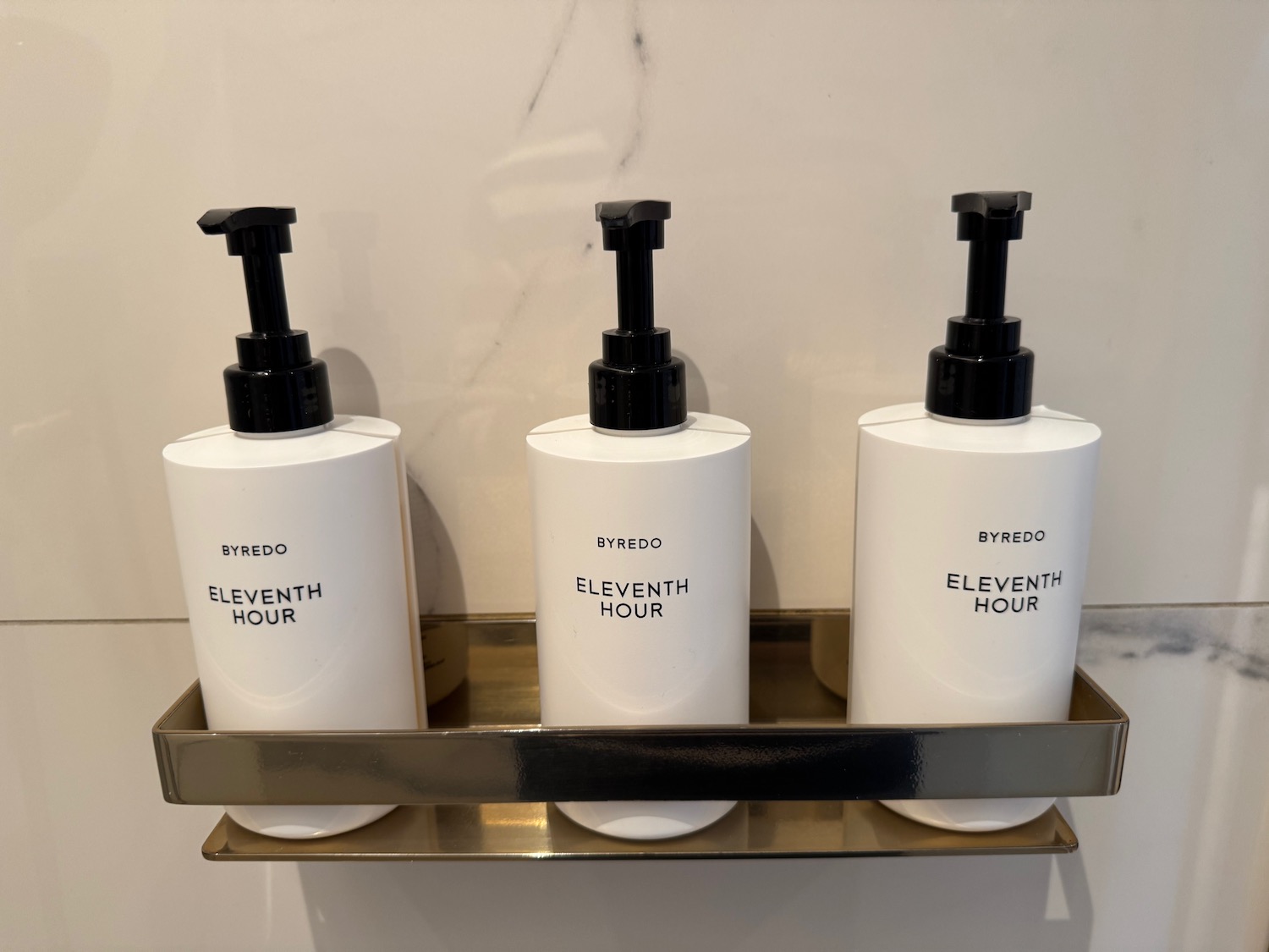 a group of white bottles with black lids on a metal shelf