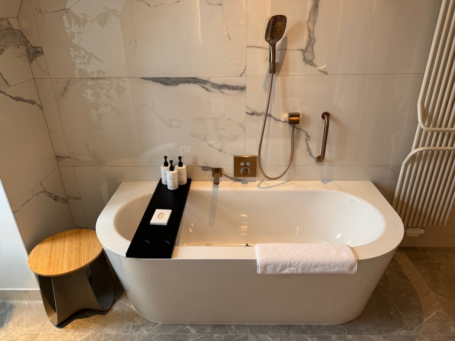 a bathtub with a shower head and a towel on the side