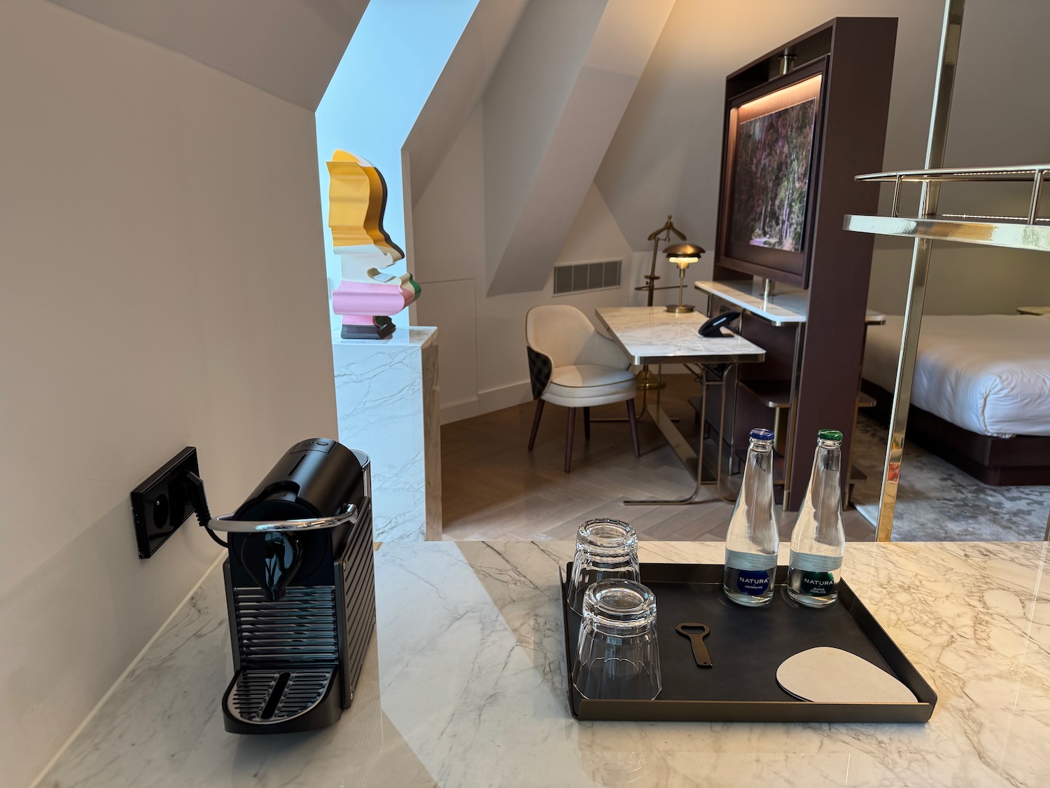 a coffee machine and glasses on a tray in a room