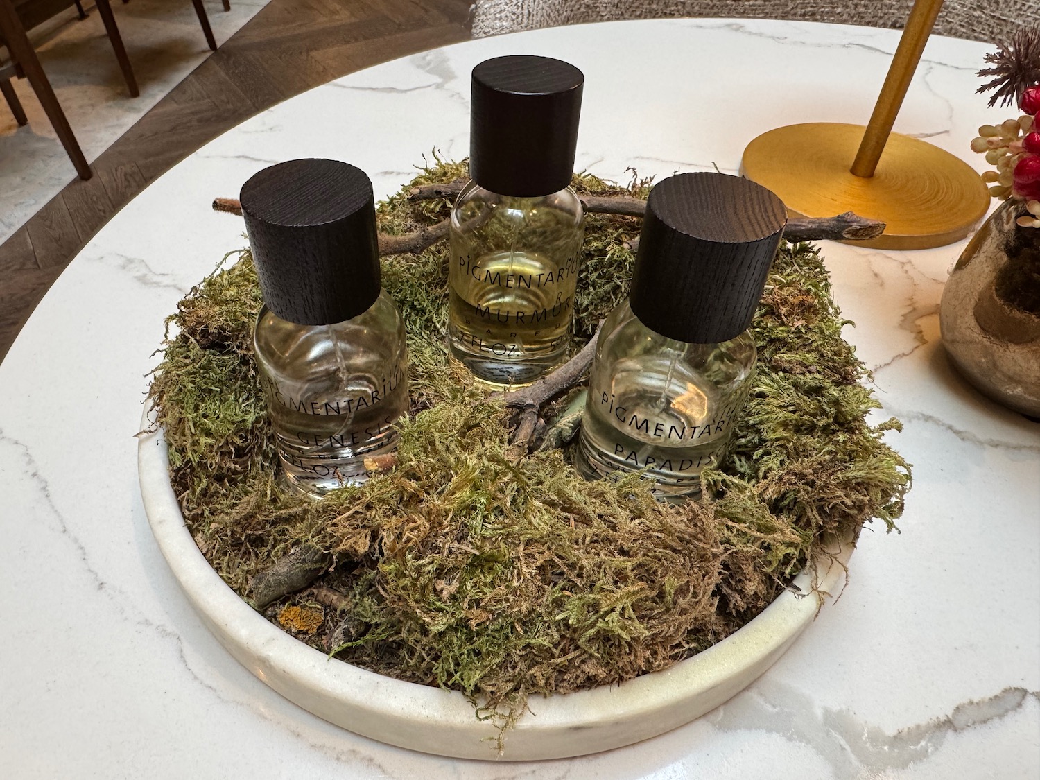 a group of small bottles with black caps on moss