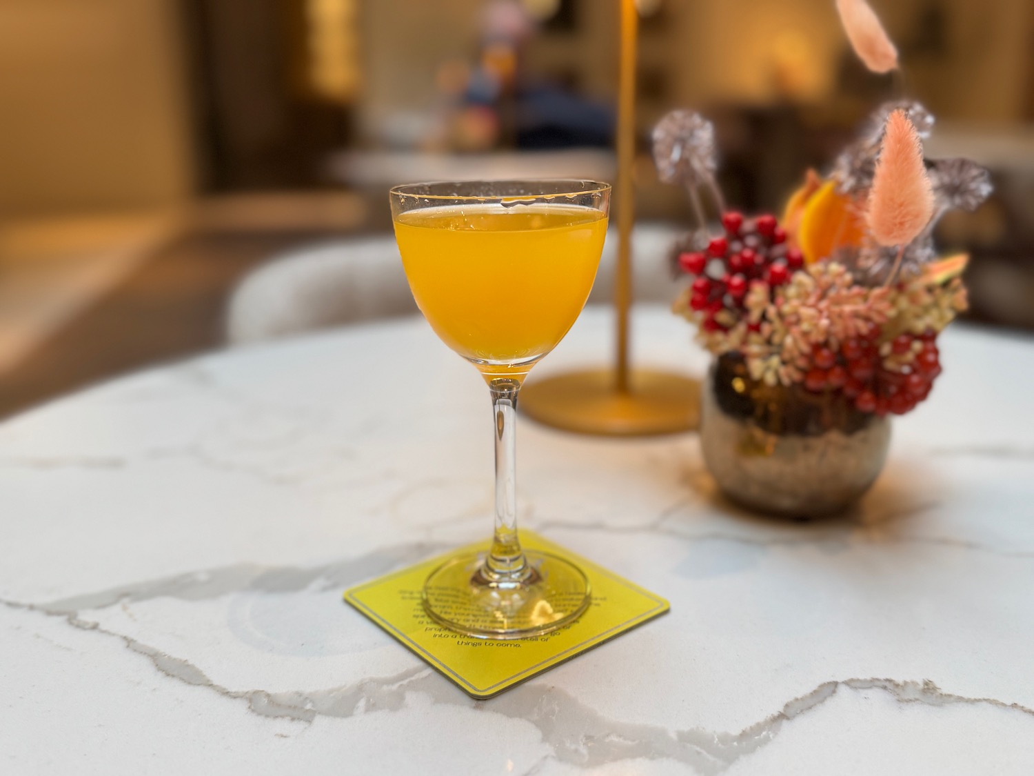 a glass of orange liquid on a table