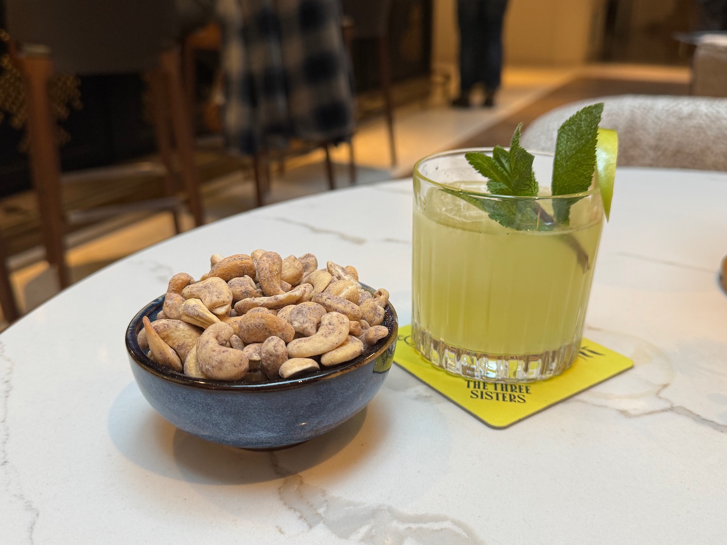 a bowl of nuts and a drink on a table