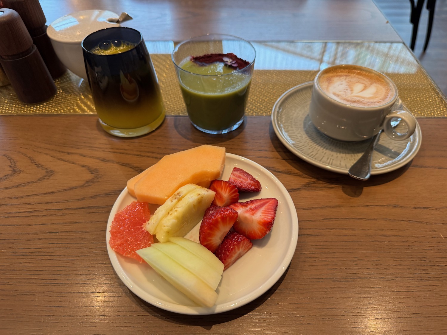 a plate of fruit and a cup of coffee on a table