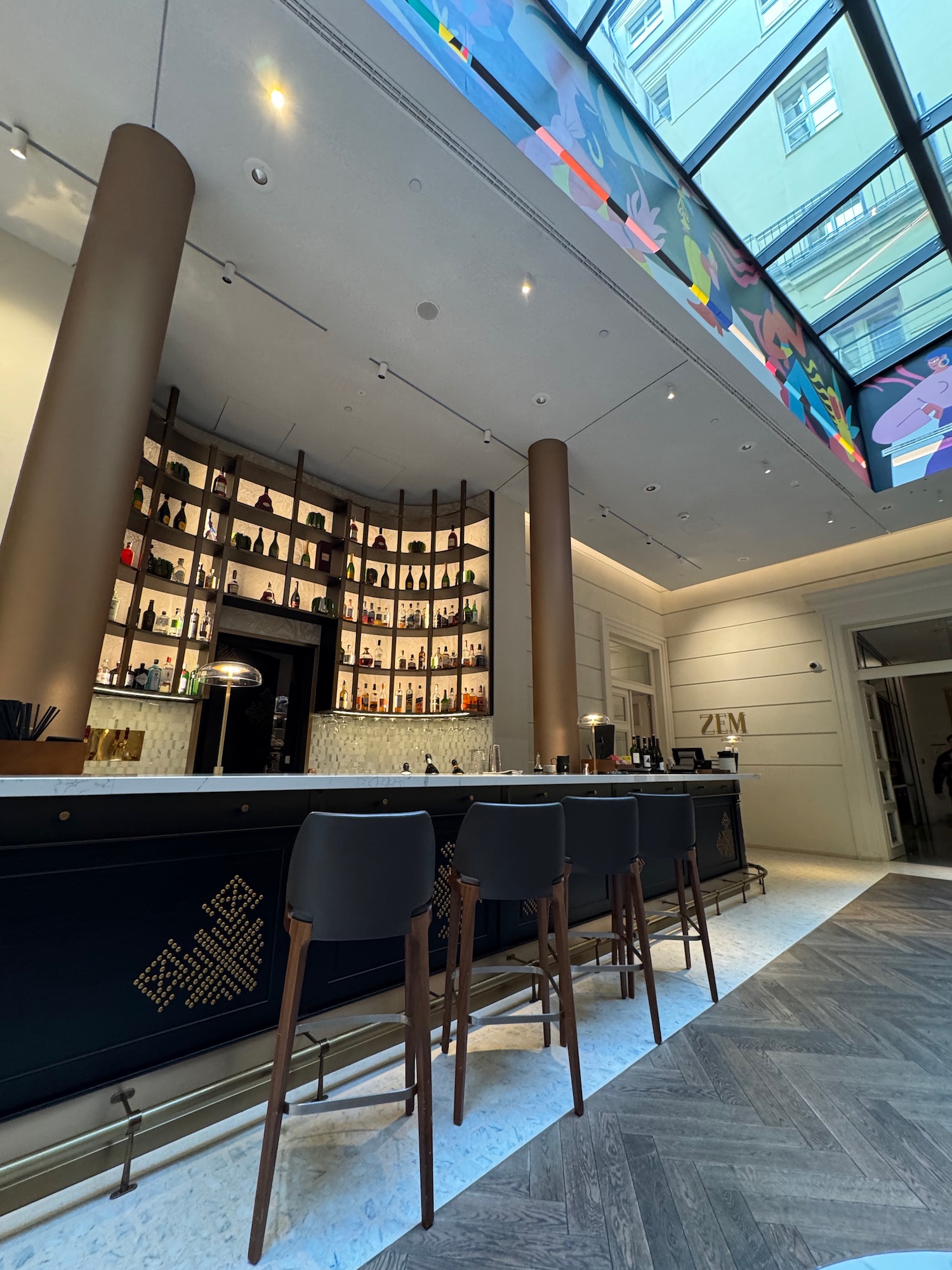 a bar with chairs and a large window