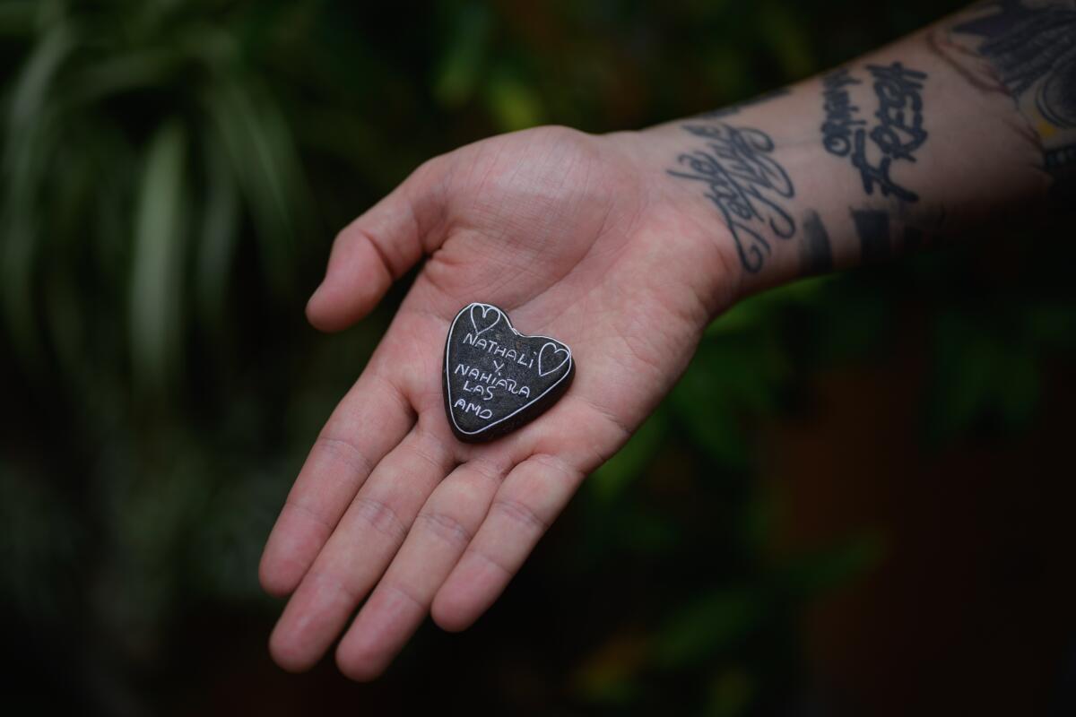 A brown-colored handmade heart displayed on an open palm