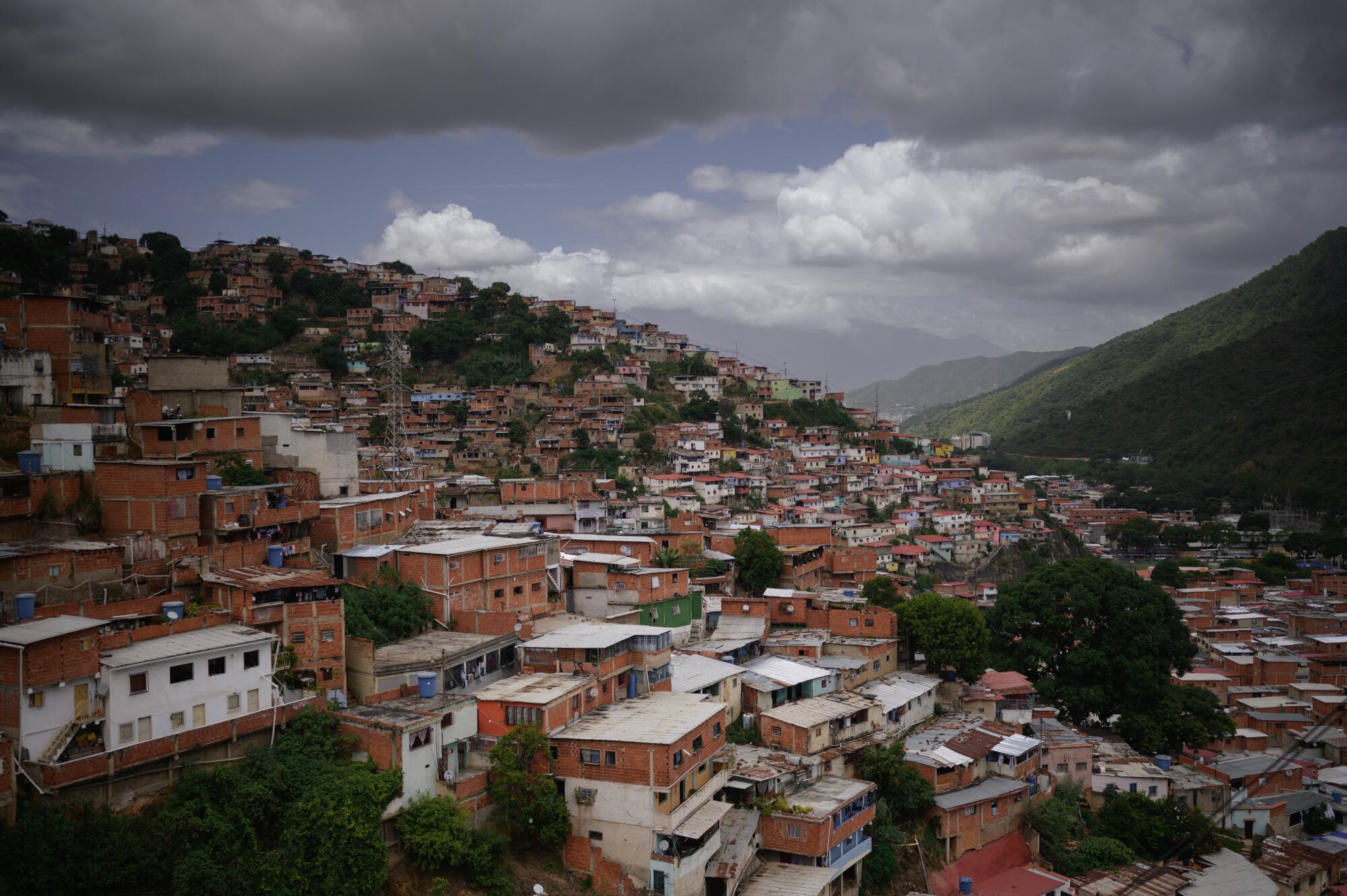 A view of homes covering a hillside, with dark clouds overhead