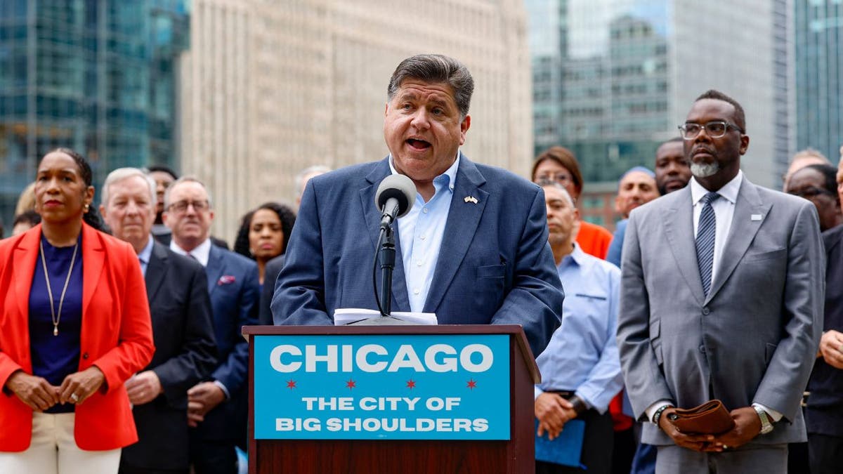 Illinois Gov. J.B. Pritzker speaks at a news conference in downtown Chicago, flanked by state and city leaders.
