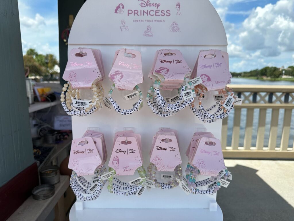 A person looks at souvenirs on a rotating display stand in a store, with pins and keychains arranged neatly.