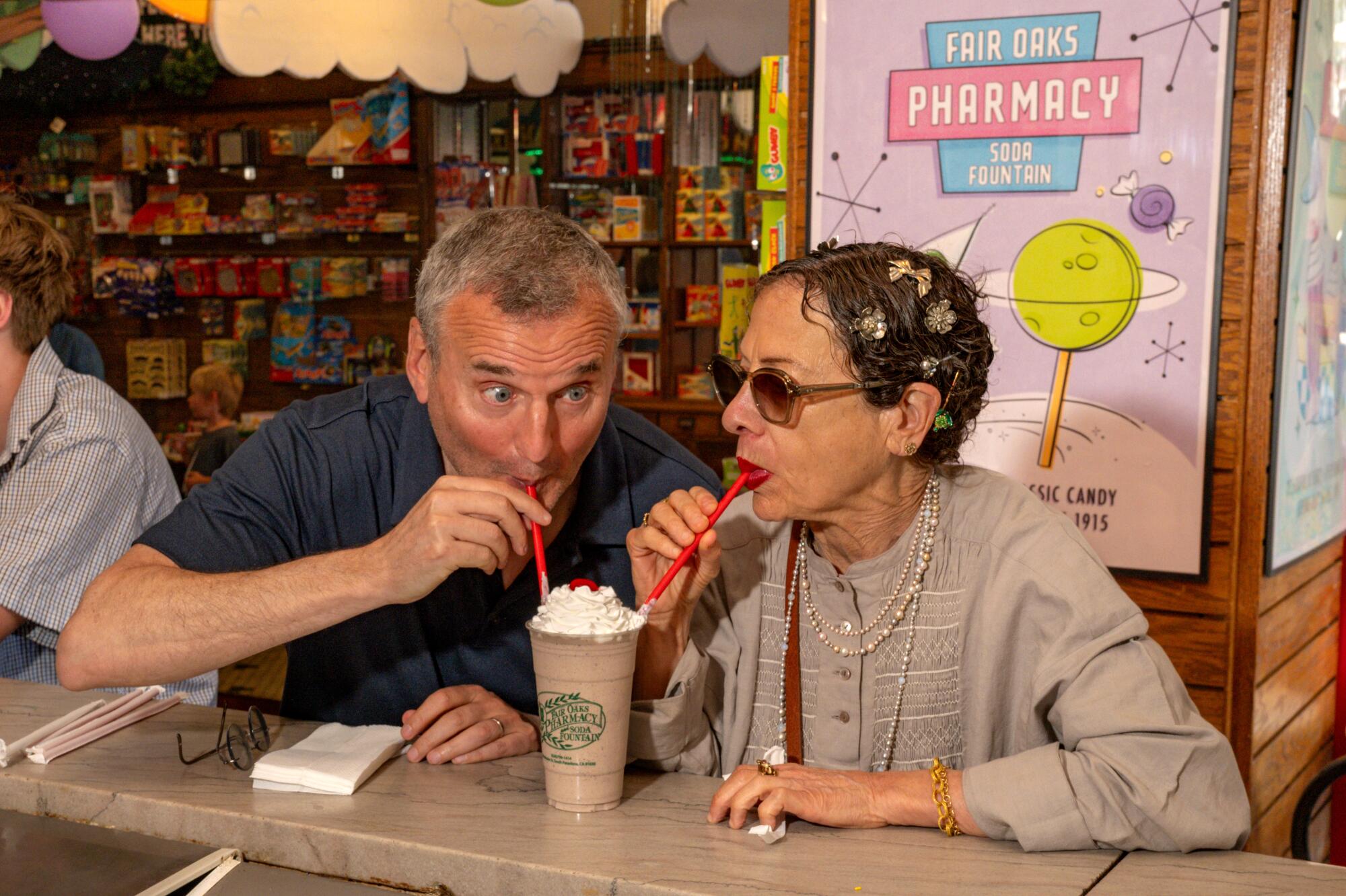 Chef Nancy Silverton and Phil Rosenthal sharing a milkshake 