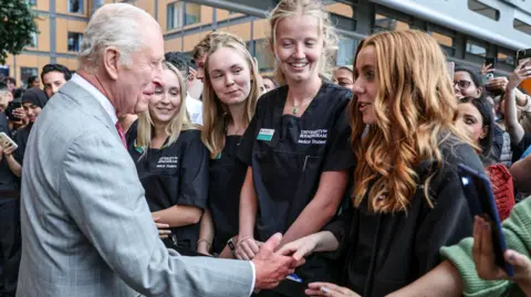 Reuters The King with nurses at at the opening of a new hospital in Smethwick