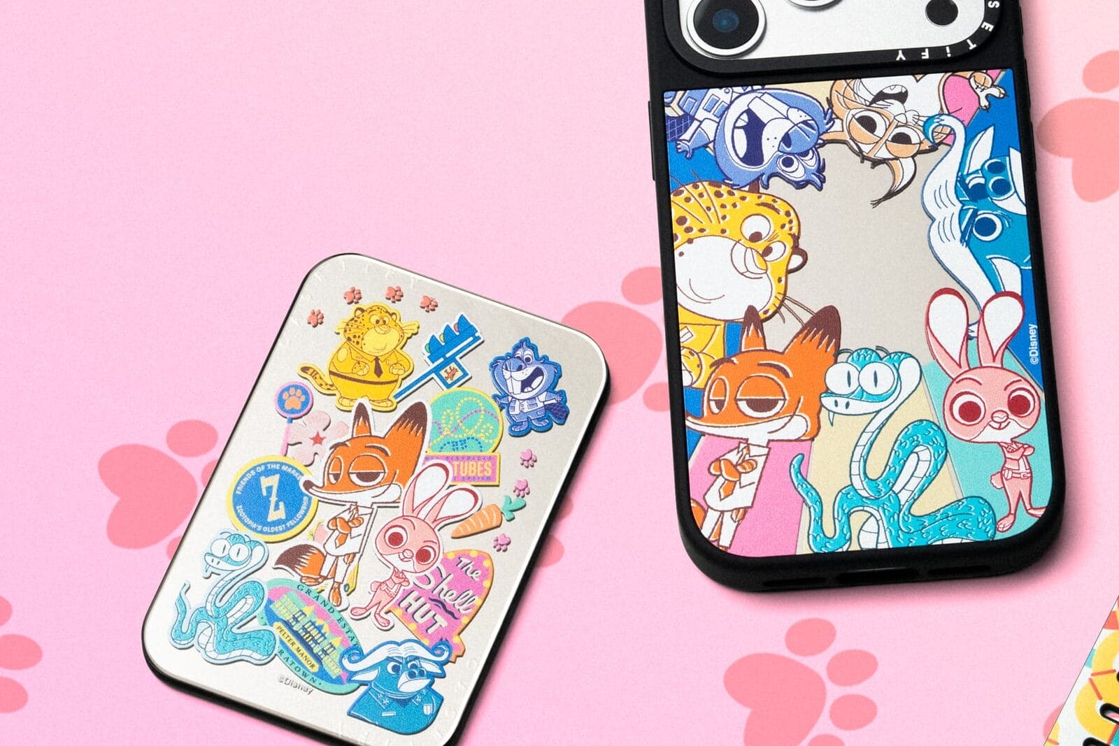 Vibrant Zootopia merch from Disney Store: phone case, card holder, and smartwatch band with paw prints; no castle pictured.