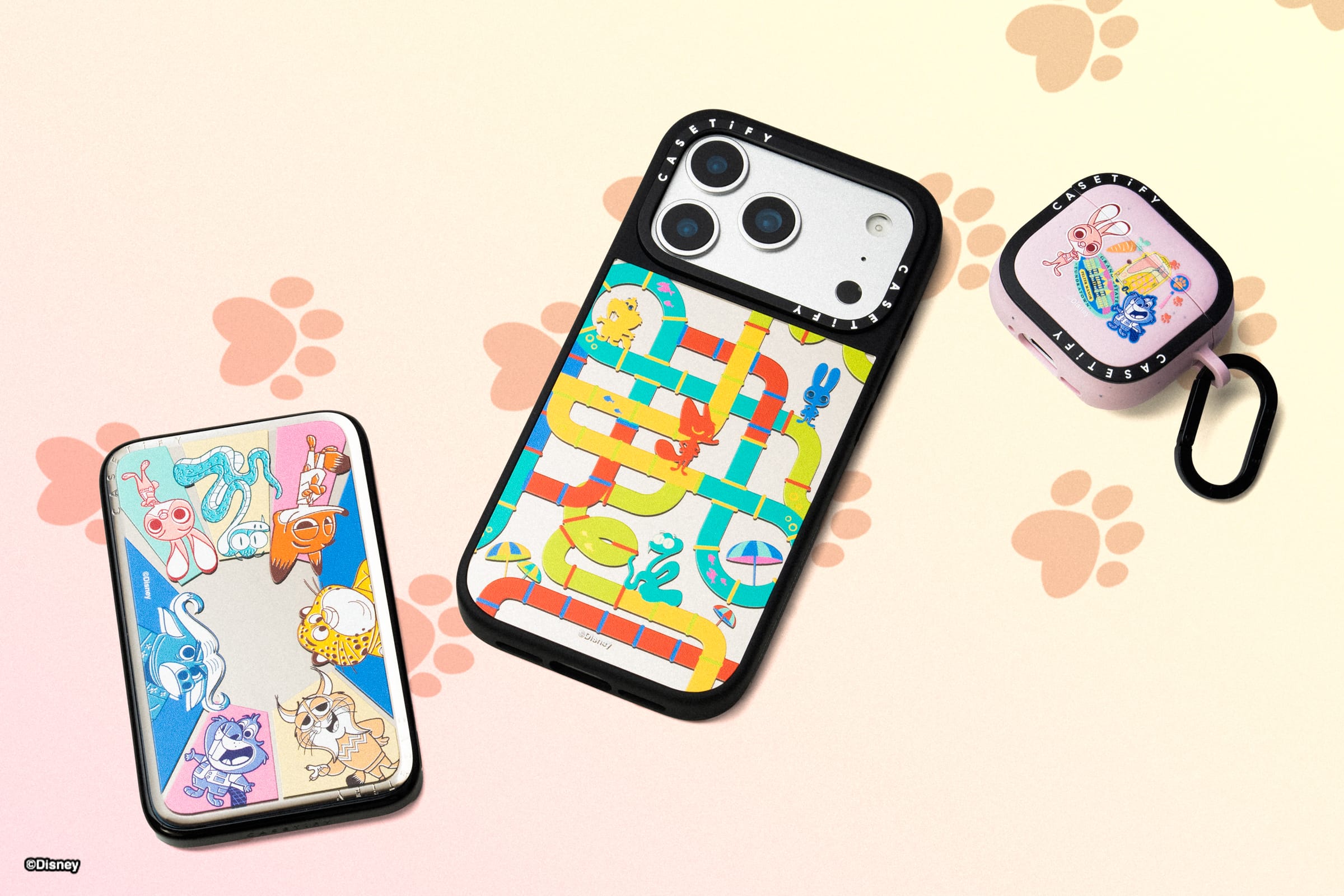 Three Zootopia-inspired electronic cases with colorful animal designs on a pastel background with paw prints, like park merch.