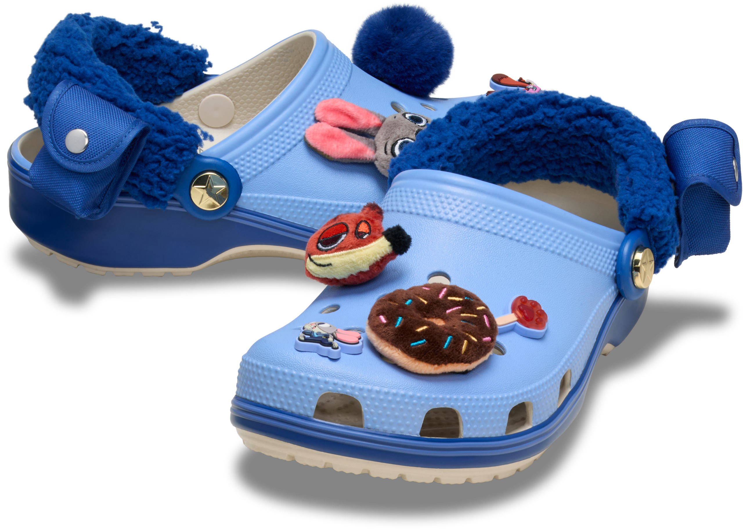 Light blue Crocs with fuzzy lining and vibrant plush Disney charms—whimsical Zootopia 2 park merchandise, perfect for castle fans.