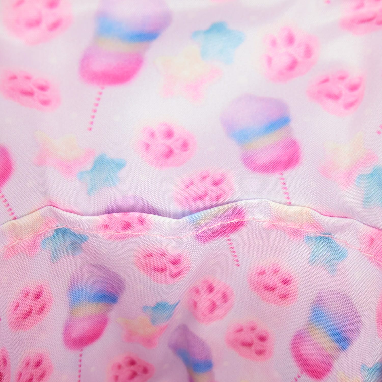 Pastel Disney Zootopia 2 fabric with pink, blue, and yellow cotton candy, stars, and paw prints on light pink—no castle visible.