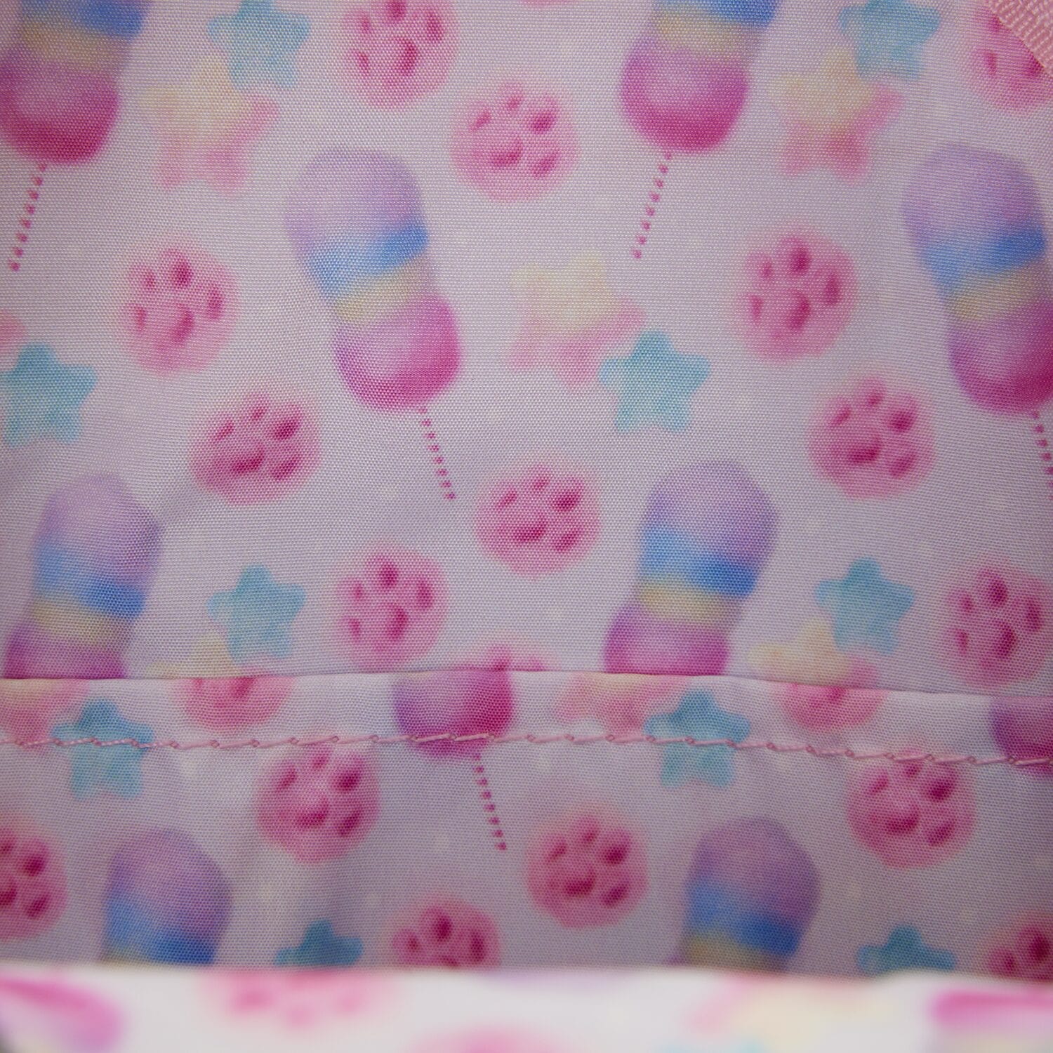 Pink fabric with pastel cotton candy, blue and yellow stars, pink paw prints—ideal for Zootopia 2 merch at Disney Parks worldwide.