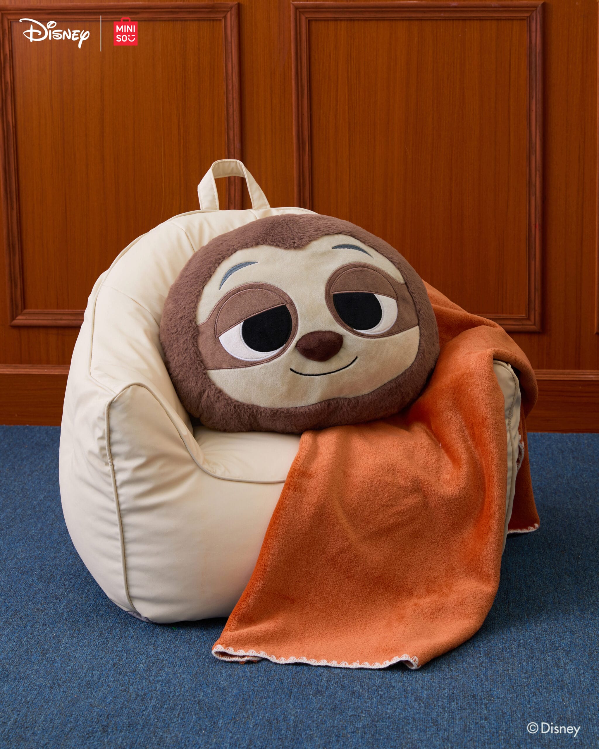 A Zootopia 2 plush rests on a bean bag, styled like those found in Disney Park shops near the iconic castle entrances.
