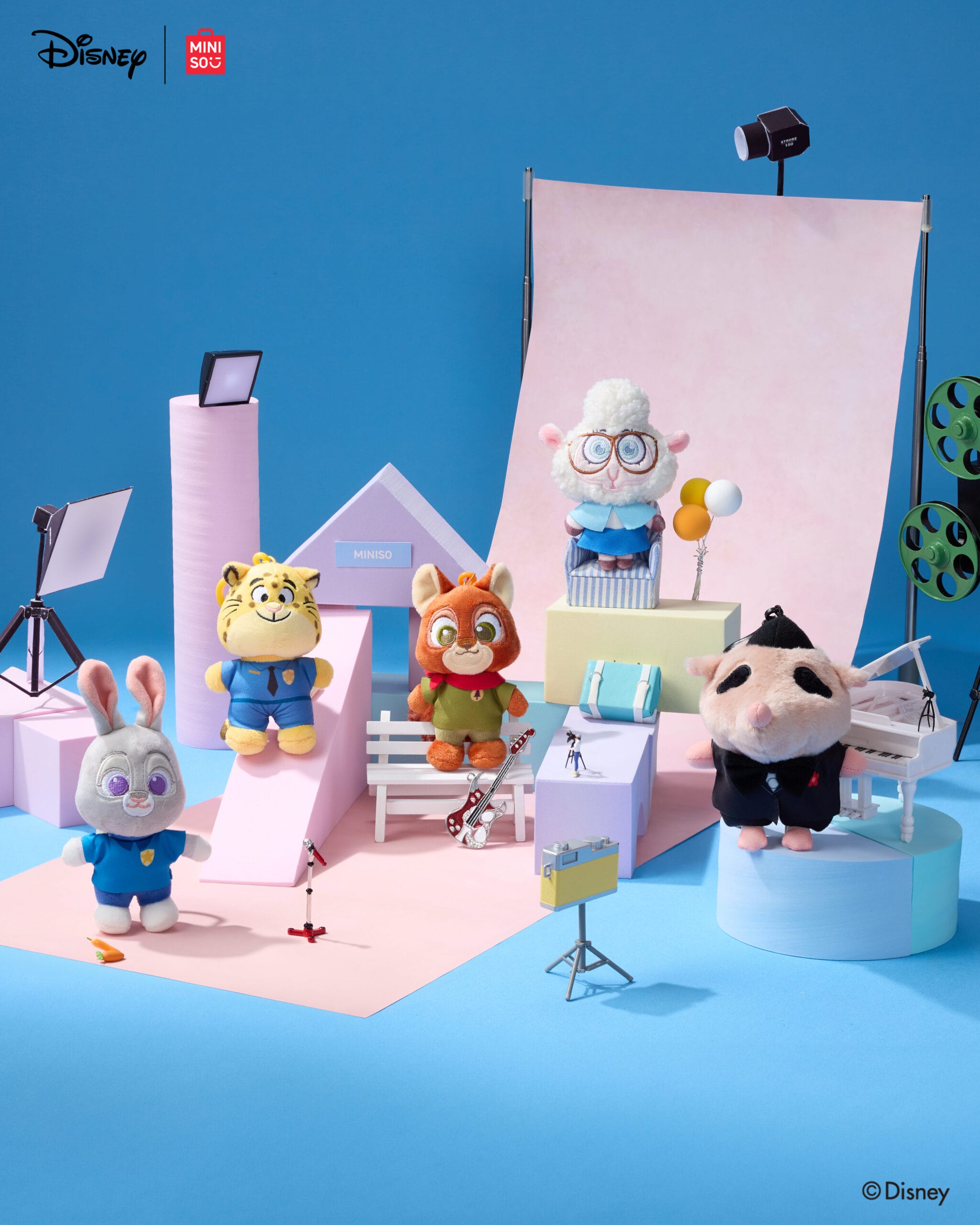 Five Zootopia plush toys from the Disney Store on a pastel set with movie props, just like those in Disney Parks shops worldwide.