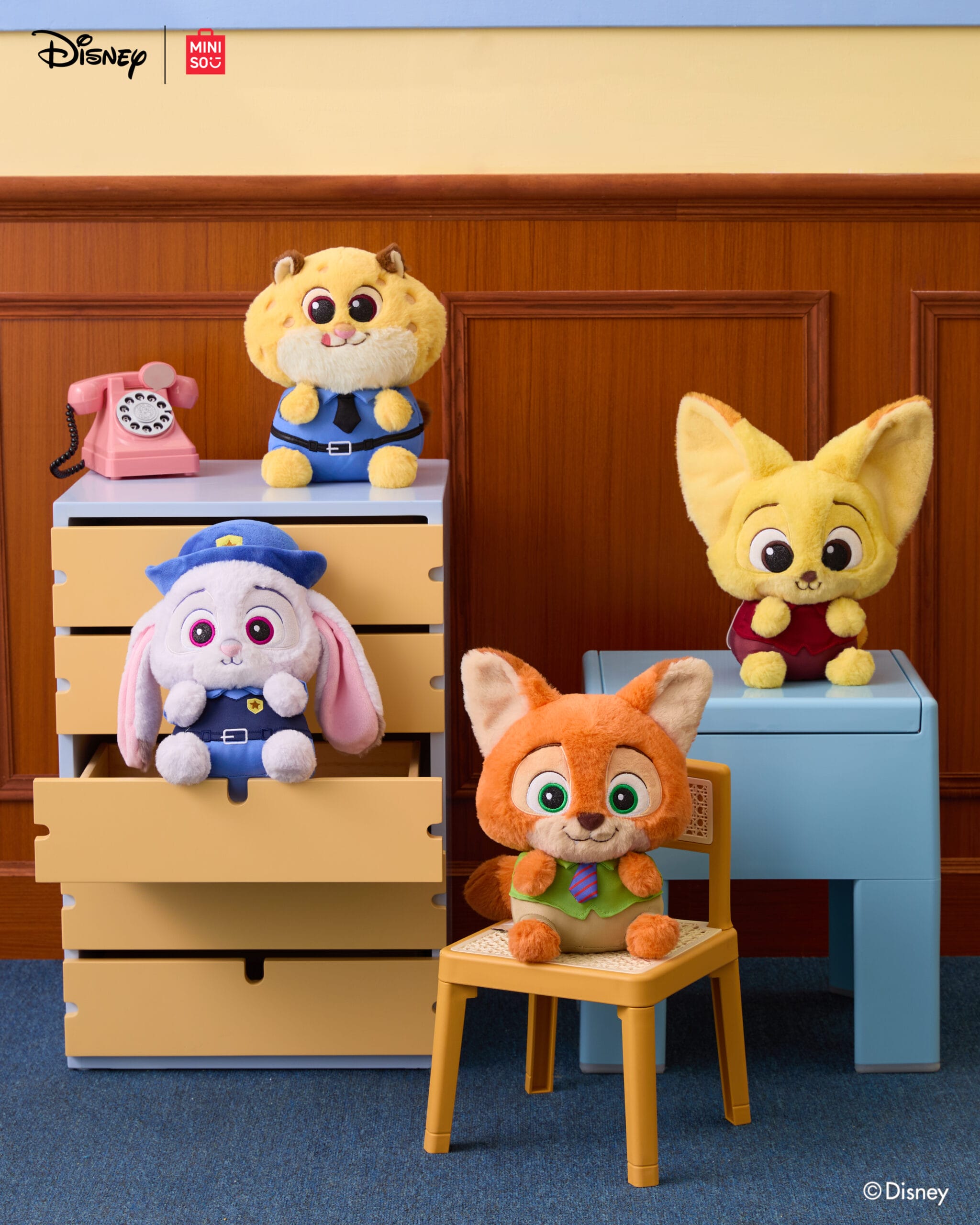 Four Zootopia Disney Store plushies arranged on pastel seats, pink rotary phone nearby, evoking Disney Park boutique vibes.