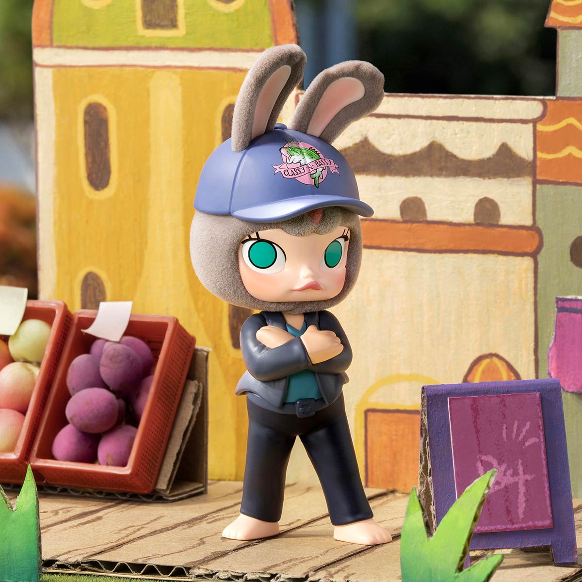 A toy bunny-eared figure with crossed arms by fruit baskets, a fun Zootopia 2 souvenir like those found in Disney park shops.