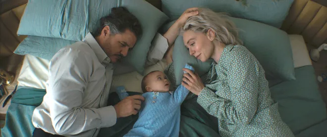 Reed Richards (Pedro Pascal, left) and wife Sue Storm (Vanessa Kirby) aim to keep their newborn son Franklin (Ada Scott) safe from a cosmic menace in Marvel's
