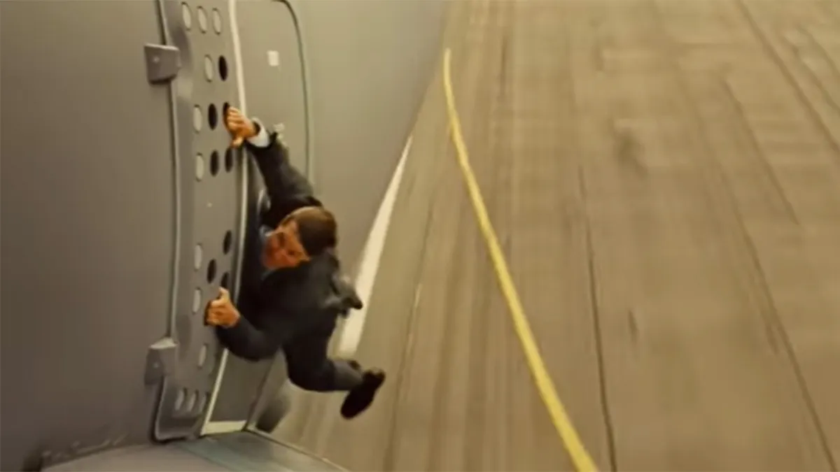 Tom Cruise hanging off the side of a plane in a stunt for Mission Impossible Rogue Nation.