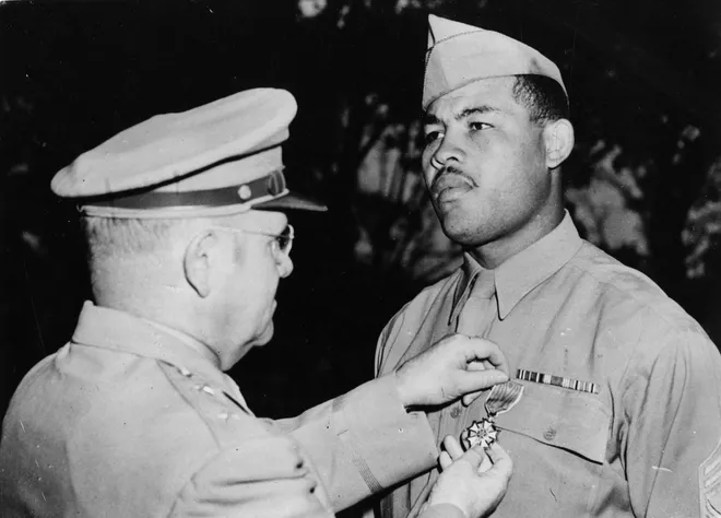 Heavyweight boxer Joe Louis is presented with the Legion of Merit medal by Major-General Clarence H Kells during a ceremony at Port Hamilton on Sept. 28, 1945. The award is in recognition of Louis' 'exceptionally meritorious conduct in the performance of outstanding services' during his tour of army camps and hospitals.