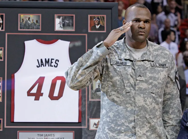 Tim James receives the Miami Heat's Home Strong Program award which recognizes military members who have recently returned from deployments to Iraq or Afghanistan before the start of the game between the Miami Heat and the Denver Nuggets on March 19, 2011 at American Airlines Arena in Miami, Fla. James served after his NBA career.