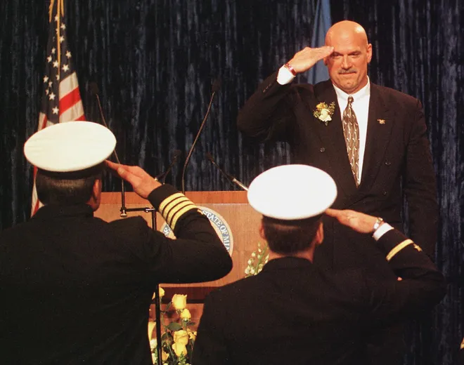 Minnesota Governor Jesse Ventura salutes Naval Officers he invited to his inaugural after taking the oath of office to become Minnesota's 38th governor at the State Capitol Monday afternoon Jan. 4, 1999 in St. Paul, Minnesota. The former professional wrestler served in the navy during Vietnam between 1969-1975 as part of an Underwater Demolition Team, later known as SEAL Team.
