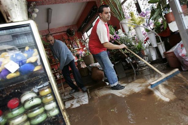 People clean a flooded store after a heavy rainfall in Santa Cruz de Tenerife on the Spanish Canary island of Tenerife, on February 2, 2010. Heavy storms have caused flooding and left thousands without electricity in Spain's Canary Islands, a major tourist destination, local authorities said. AFP PHOTO / DESIREE MARTIN (Photo credit should read DESIREE MARTIN/AFP via Getty Images)