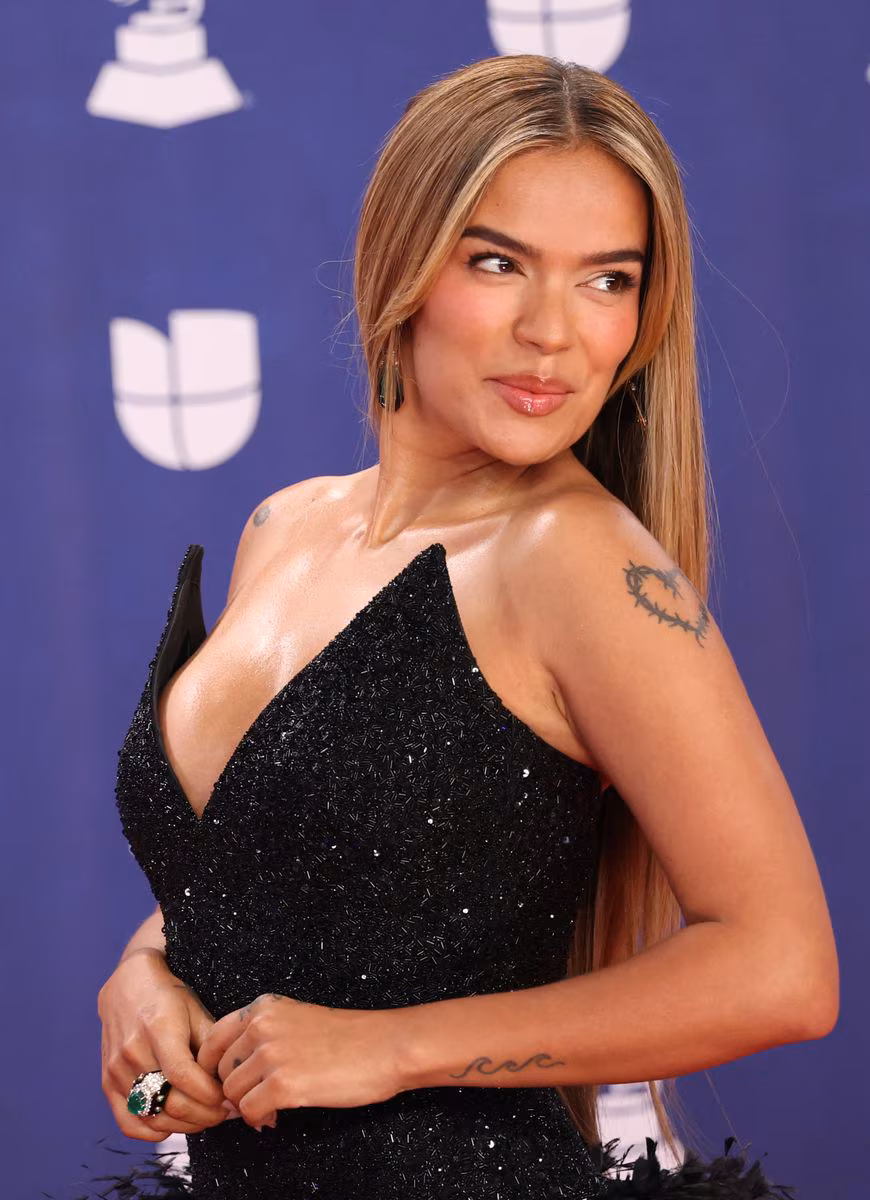 Karol G's all-black look featured a dramatic burst of black feathers at the waist