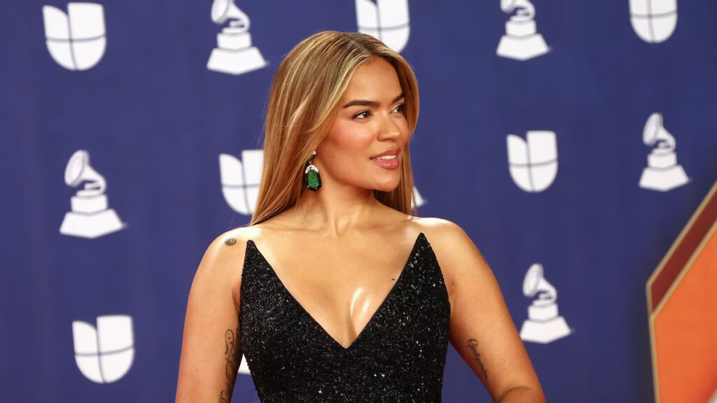 Karol G turns heads in dramatic black feathered gown with emerald accessories at the Latin Grammys