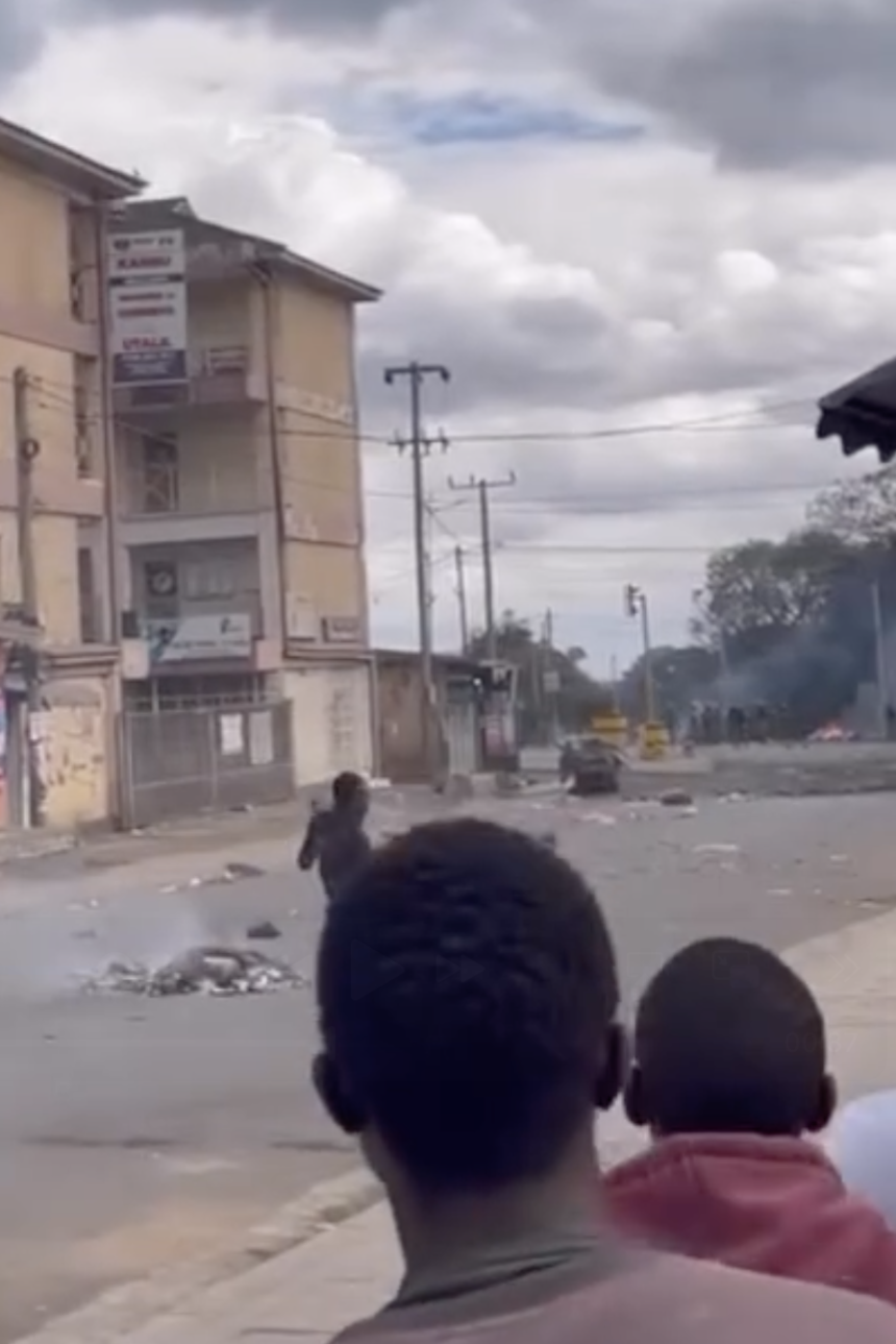 A protester is seen walking towards a police position at the top of the road in Arusha, on October 29, 2025.