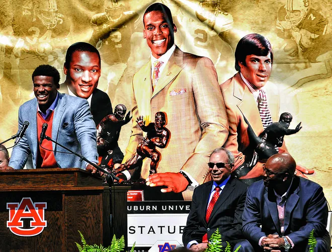 Cam Newton, left, speaks as fellow heisman trophy winners Pat Sullivan, center, and Bo Jackson listen during the unveiling ceremony of the Heisman statues at Jordan Hare Stadium in Auburn, Ala. on Saturday April 14, 2012.(Montgomery Advertiser, Mickey Welsh)