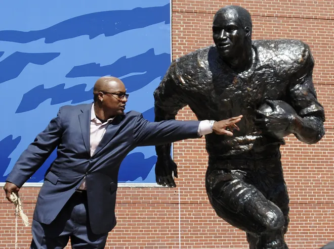 Bo Jackson touches a statue of himself during the unveiling ceremony for the Heisman statues at Jordan Hare Stadium in Auburn, Ala. on Saturday April 14, 2012.(Montgomery Advertiser, Mickey Welsh)