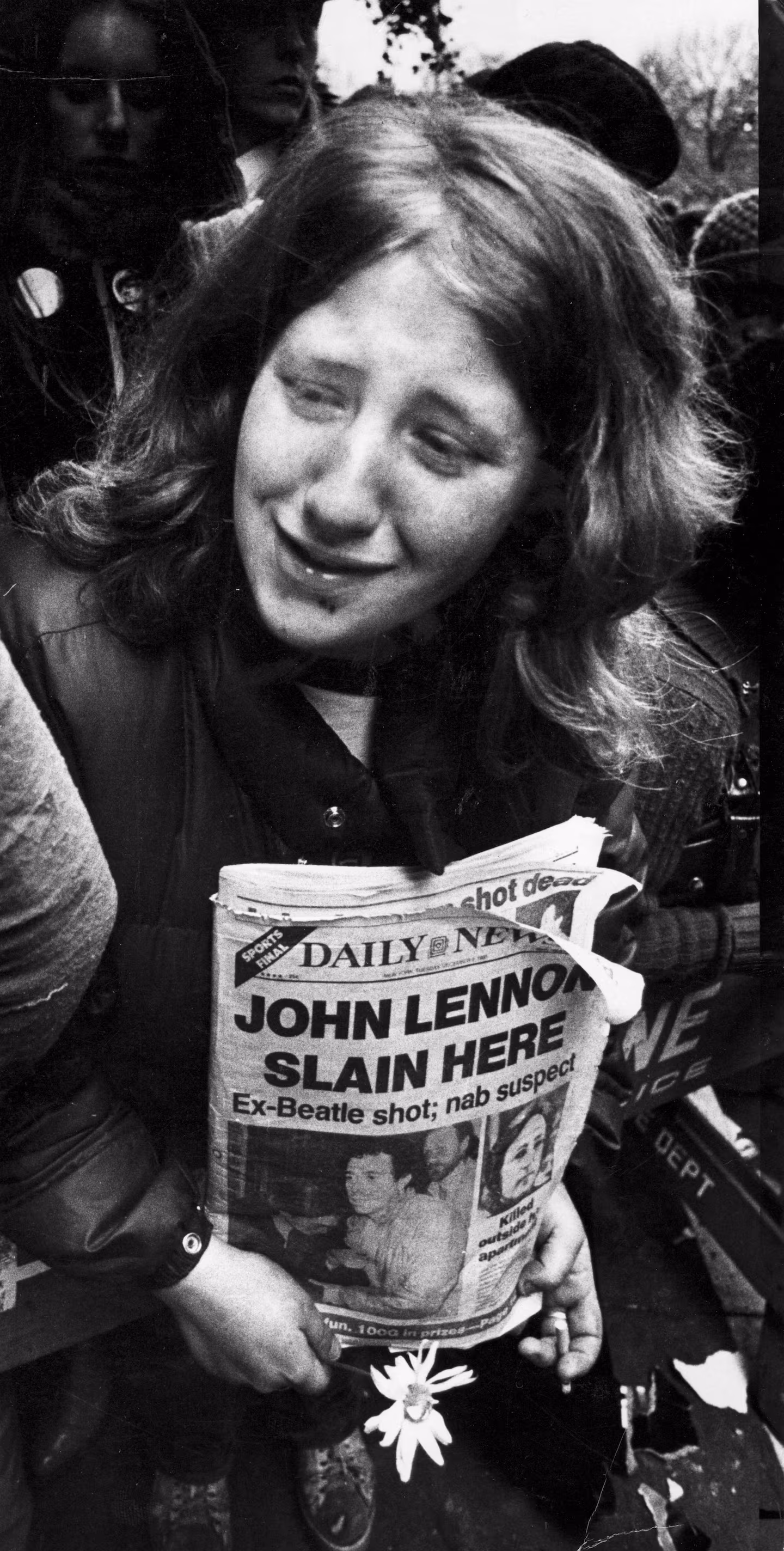 A woman weeps in front of the Dakota Apartments the morning after a gunman shot and killed John Lennon in New York City, Dec. 9, 1980.