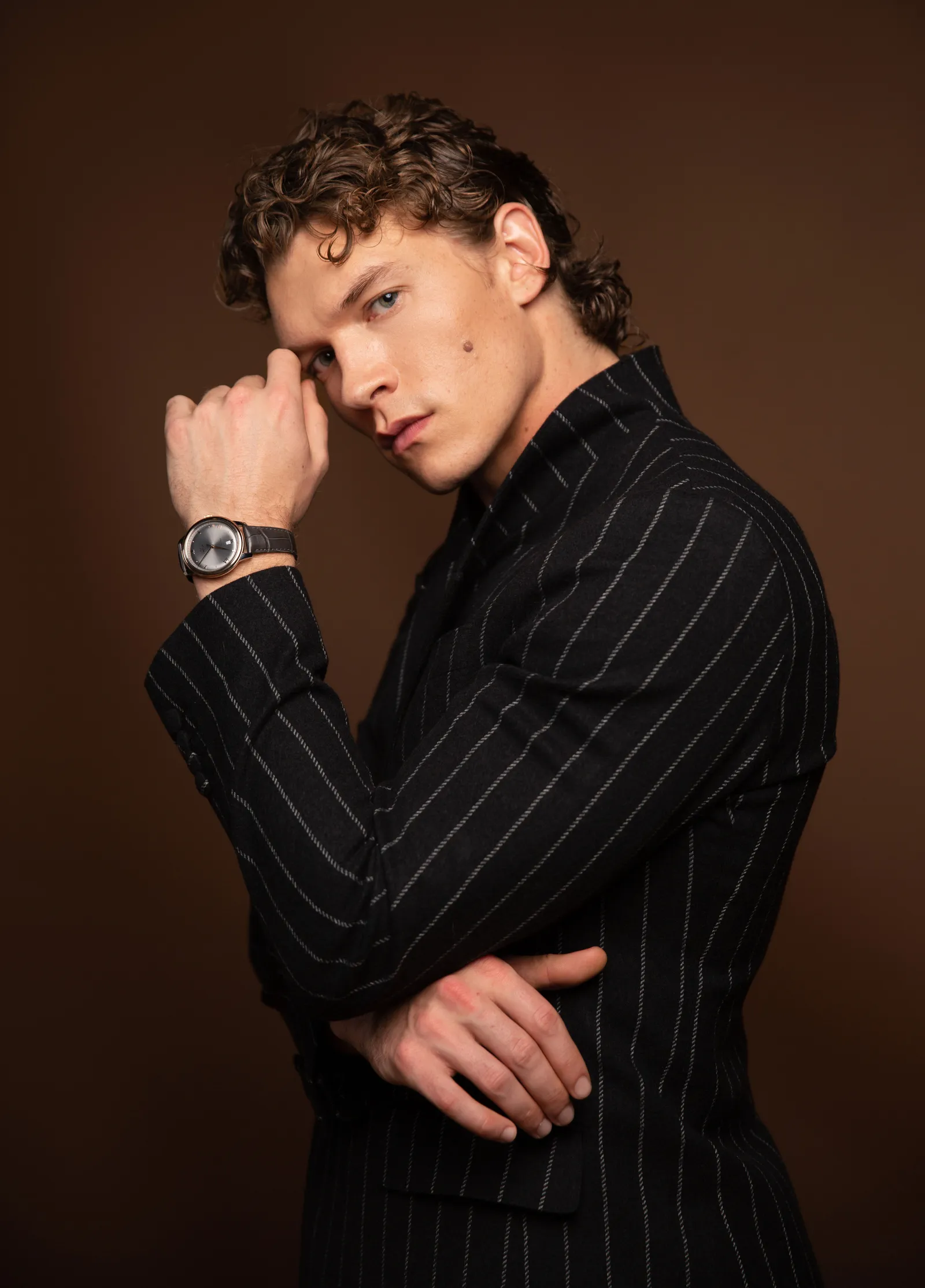 Image may contain Clothing Formal Wear Suit Face Head Person Photography Portrait Adult Body Part Finger and Hand