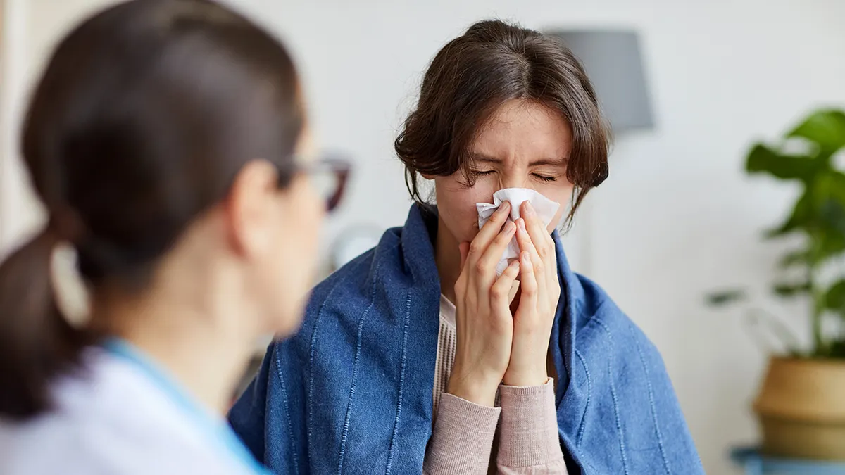 Sick woman caught a cold she has running nose.