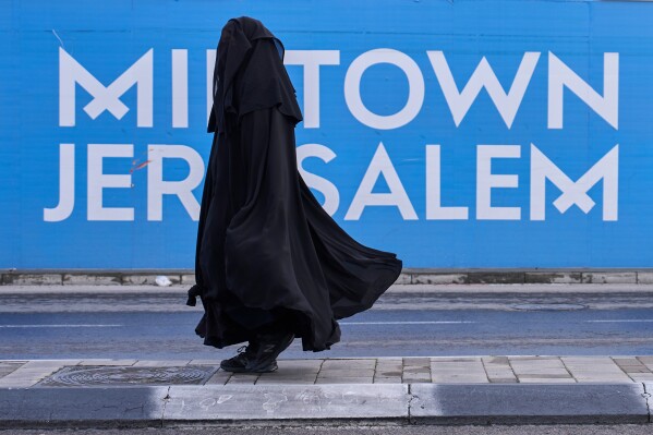 A Jewish woman from the Haredi burqa sect makes her way through central Jerusalem, on Tuesday, Dec 30, 2025. (AP Photo/Ohad Zwigenberg)