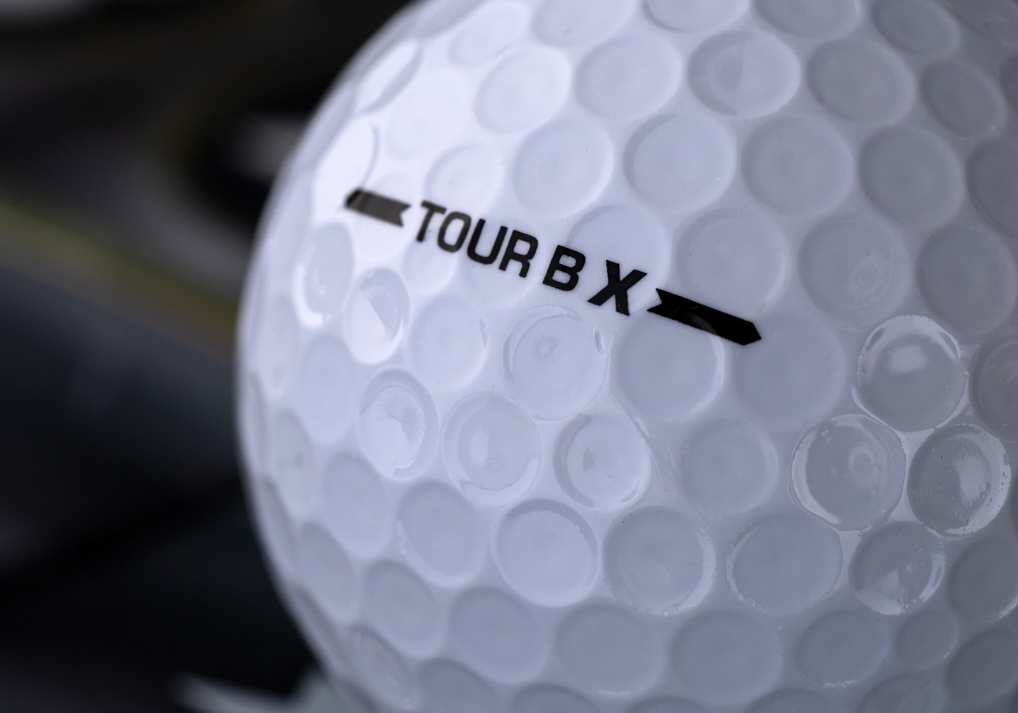 A closeup of a Bridgestone TOUR B X golf ball