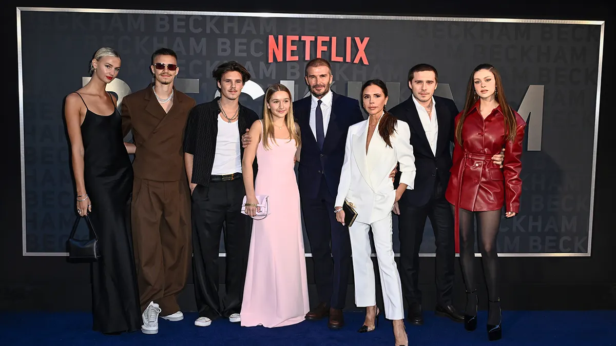 the beckhams and nicola posing on a red carpet
