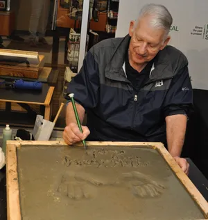 Mickey Lolich writes his name after casting his hands in cement for the Detroit Historical Museum's Legends Plaza on Saturday, Oct. 6, 2018.